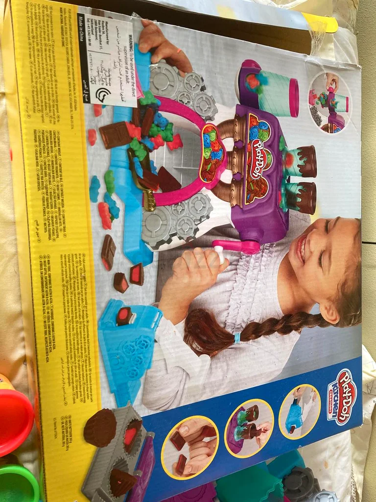 أطفال يلعبون بآلة صنع العجين63207397405953114