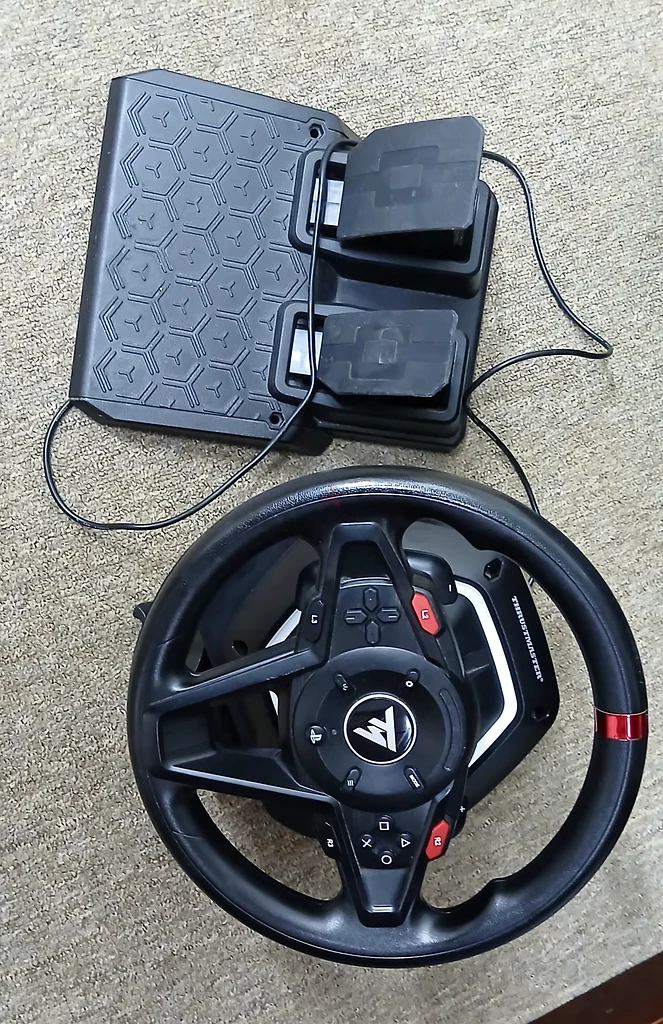 Very clean Thrustmaster T128 PS5 with adapter, wires, and full pedals, nothing missing.63229685657857111