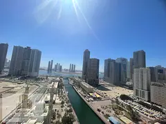 For sale, an apartment with a distinctive open view of Al Qasba Canal and Al Mamzar Lake, with a pan