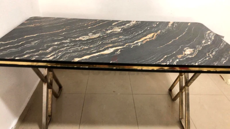 طاولة أنيقة بسطح من الرخام الأسود وإطار معدني أنيق632163471047711122