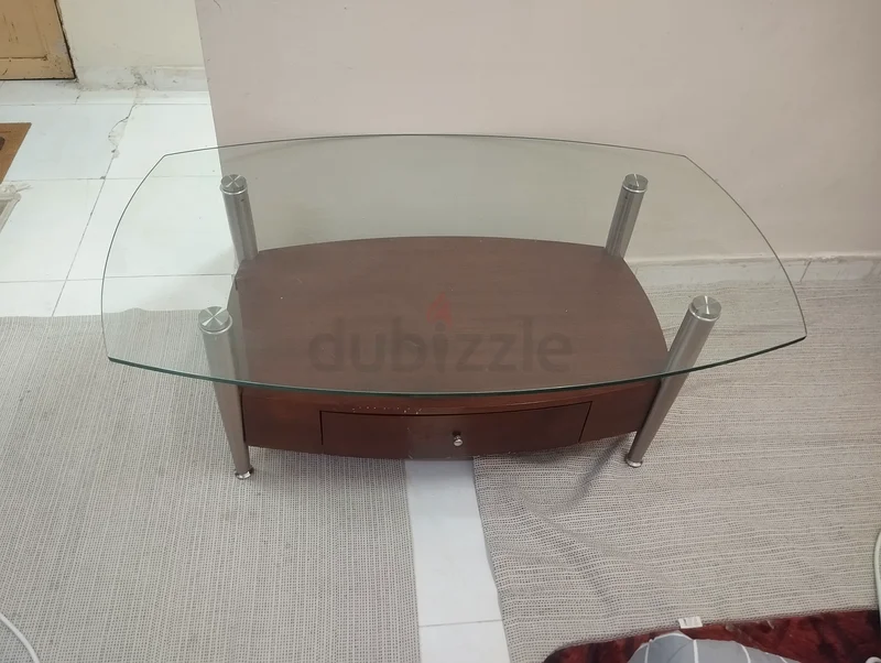 A modern wooden and strong glass table suitable for TV or multipurpose seating, featuring a drawer.63216348005889114
