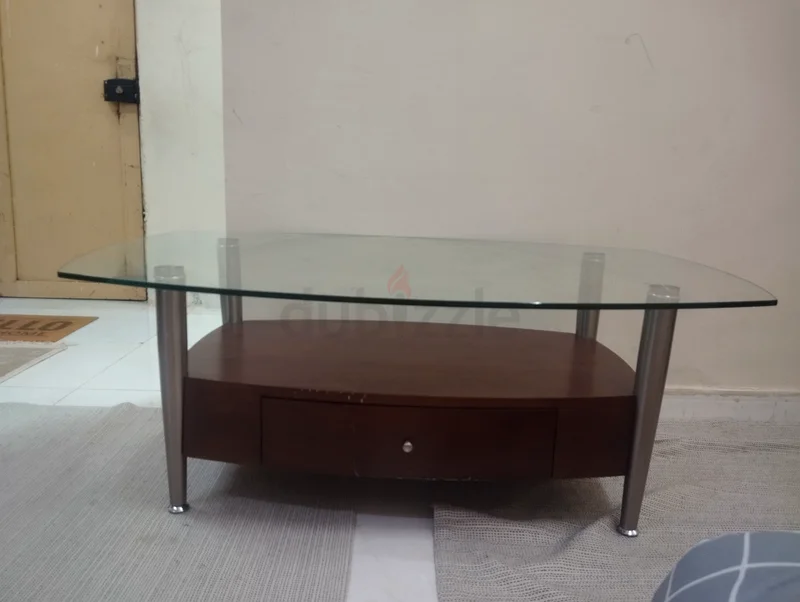 A modern wooden and strong glass table suitable for TV or multipurpose living room use, featuring a drawer.63187703355649113