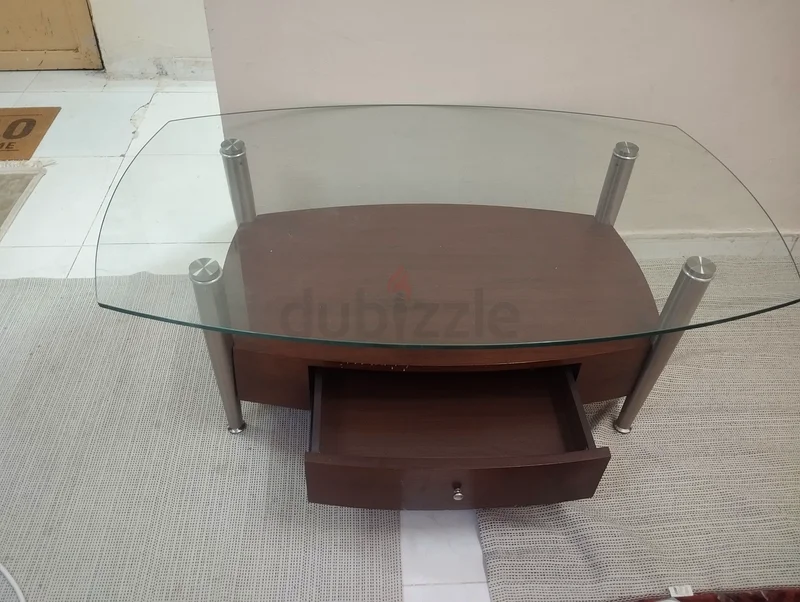 A modern wooden and strong glass table suitable for TV or multipurpose living room use, featuring a drawer.63187703355649114