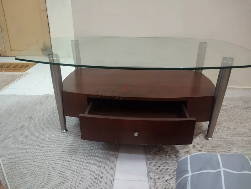 A modern wooden and strong glass table suitable for TV or multipurpose living room use, featuring a drawer.63187703355649112