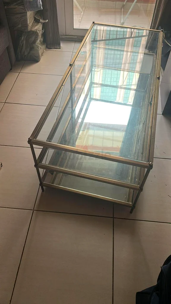 طاولة قهوة أنيقة بسطح من الزجاج وإطار ذهبي632108933277461129