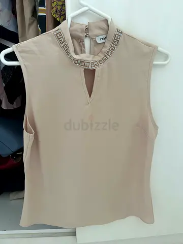 Elegant Beige Sleeveless Top with Intricate Neckline