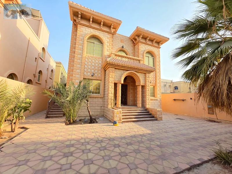 Luxury villa for rent in Al Rawda 2 in Ajman, the second plot from Sheikh Amma Street, two floors with a roof, 5 master bedrooms, a hall, a council, a63723095230977110