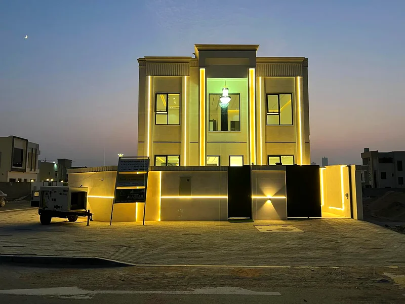 Corner villa for sale in Ajman, Al Helio 2 area, including registration fees, consisting of 4 master bedrooms, a majlis, a hall, and a large setback o63909006056705111