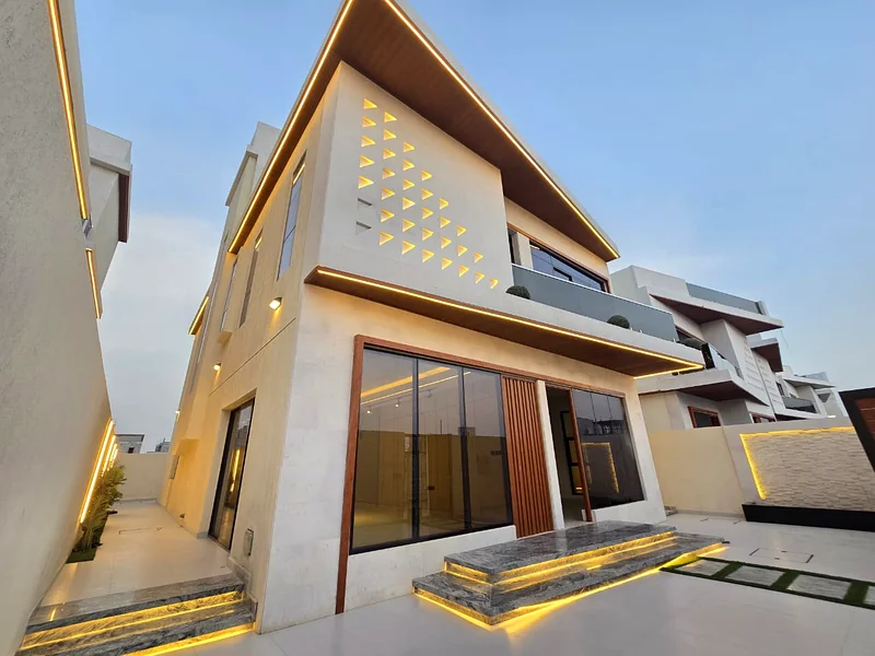 Villa for sale in Ajman, Al Helio 2 area, including registration and ownership fees, consisting of 5 master bedrooms with a majlis, a hall, and a maid63910418063746111