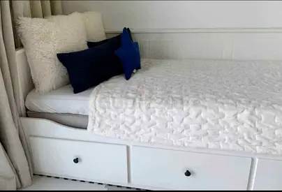 Ikea hemnes Charming White Bed with Storage and Stylish Cushions.