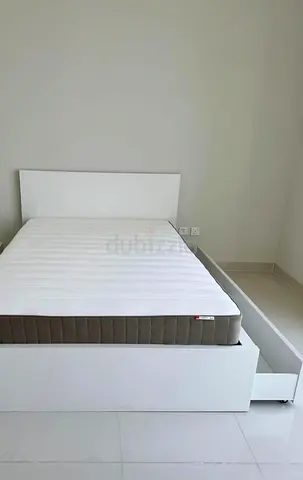 IKEA Malm Queen size bed frame with storage drawers and mattress.