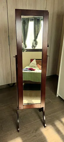 Jewellery cabinet with adjustable mirror