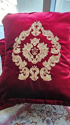 A pair of burgundy velvet cushions