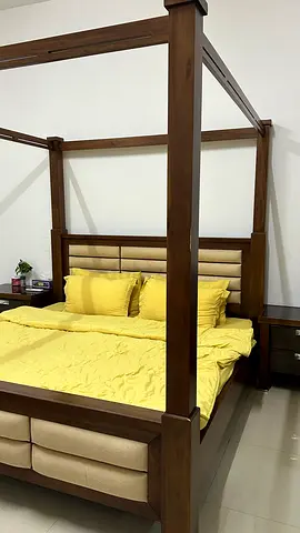 Elegant Four-Poster Bed with Soft Yellow Bedding