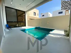 A luxurious two-story villa with a rooftop terrace, gardens, and spacious outdoor areas in the Al Ba