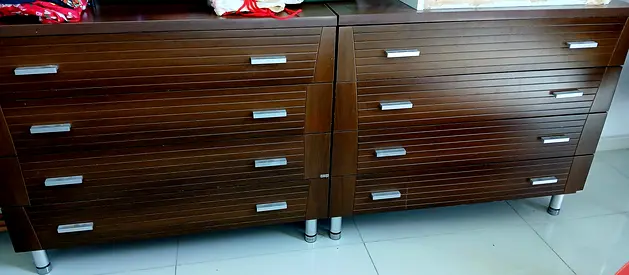 2 Wooden Nightstands, 2sets of Drawers, both have mirrors. Alongside a bed of the same style.