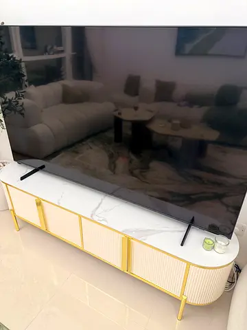 White marble TV table surrounded with gold
