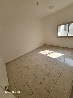 Two bedrooms and a living room with a balcony, spacious area, and a view overlooking a main street.