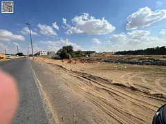 Residential land for sale on a main street with a large setback in a prime location in Al Helio 1 ar