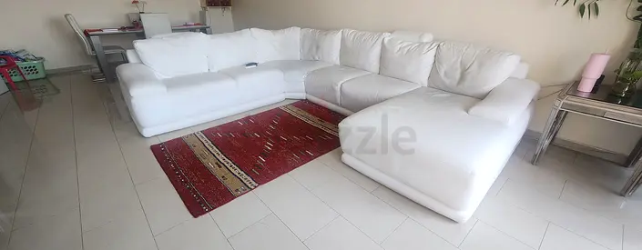 Comfortable White L-Shaped Sofa with Rug
