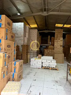 Land with a ground floor and first floor building and 6 warehouses on a main street 97 in Al Sajaa