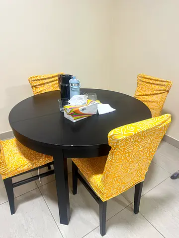 Stylish Round Dining Table with Cheerful Yellow Chairs