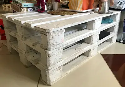 10 wooden pallets, sanded and painted white. This is a popular DIY project for creating inexpensive