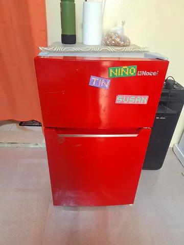 Compact Red Refrigerator with Unique Stickers
