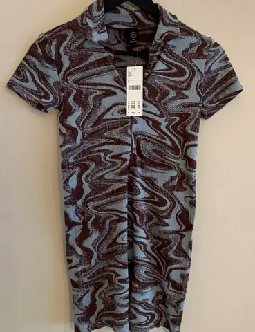 Urban Outfitters short-sleeved romper with a collar and blue and brown (burgundy) swirl print.  Deta