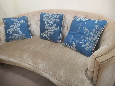 Elegant Curved Sofa with Blue Floral Pillows