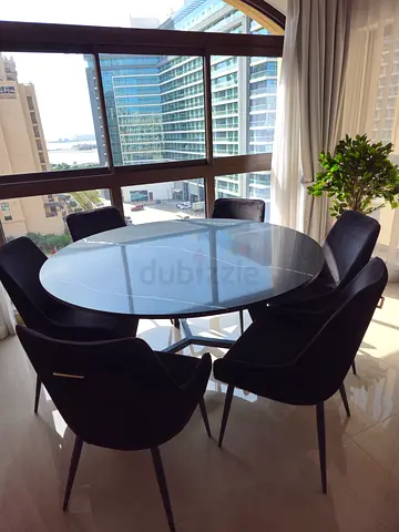 Round marble dining table with 6 black velvet chairs