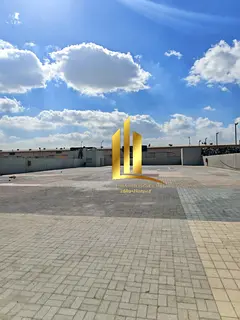 A fenced land of 20,000 square feet for rent in Al Sajaa directly on the main road.