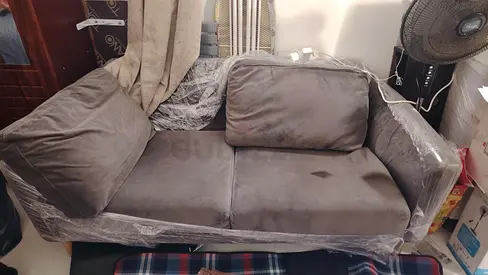 Compact Grey Sofa with Protective Wrap