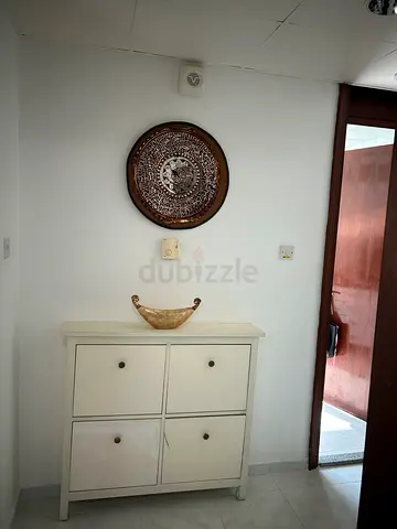 Elegant White Storage Cabinet with Decorative Wall Art