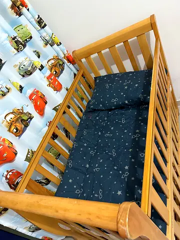 Beautiful wooden crib with cozy bedding