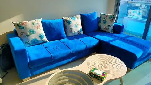 Comfortable Blue Velvet Sofa with Floral Cushions. Regularly Washed and Serviced every 6 months.