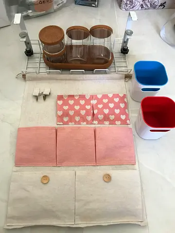 A hanging organizer or bathroom accessory set. It includes several storage items:  A hanging metal s