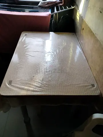 Well-Preserved Dining Table with Protective Cover