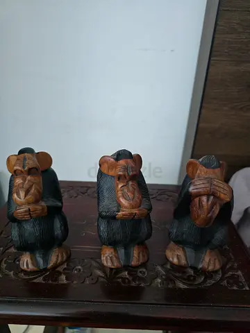 Three wooden figurines representing the Three Wise Monkeys.