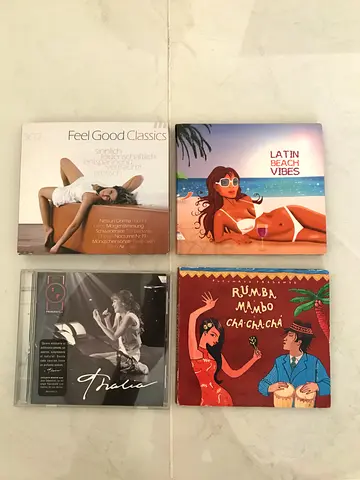 A collection of music CDs, including the album Putumayo Presents: Rumba, Mambo, Cha Cha Chá.  This a