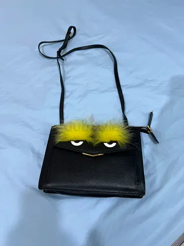 Playful Black Crossbody Bag with Unique Accessory