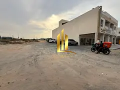 Commercial land for sale in Sharjah, Al-Hawshi, second row, Al-Badi' suburb, freehold ownership 
