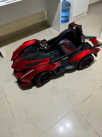 Red car ride on outside battery operated in good condition for sale