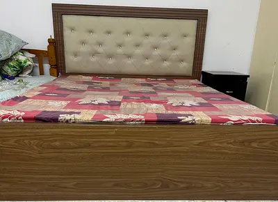 Elegant Wooden Bed with Upholstered Headboard..