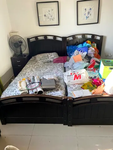 2 single beds with mattress and side table.