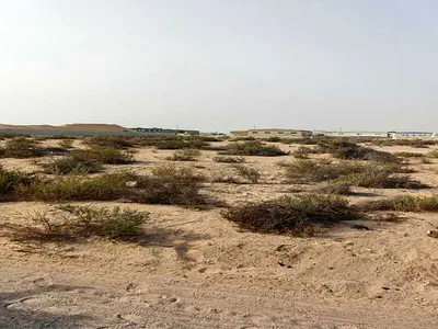Land for sale in Al Qasimia Industrial City, measuring 6,000 square feet, freehold ownership for foreigners and Arabs.