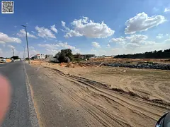 Residential land for sale on a main street with a large setback in a prime location in Al Helio 1 ar