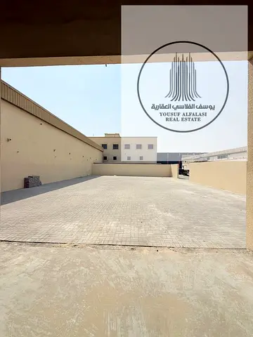 للإيجار في الجرف الصناعية 1 بعجمان – مستودع مفتوح جديد مع حوطة مغلقة بالكامل وبوابة كهربائية – مساحة إجمالية 6,365 قدم – أرضية إنترلوك – كهرباء 59 كيل
