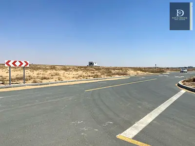 For sale in Sharjah Rawdat Al Qurt area Residential investment plot, 3,100 square feet, corner plot, on two adjacent streets