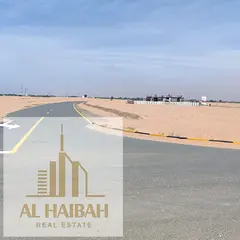 Residential lands for sale in Sharjah, Al-Zubair Gardens area, opposite the Emirates Transnational R